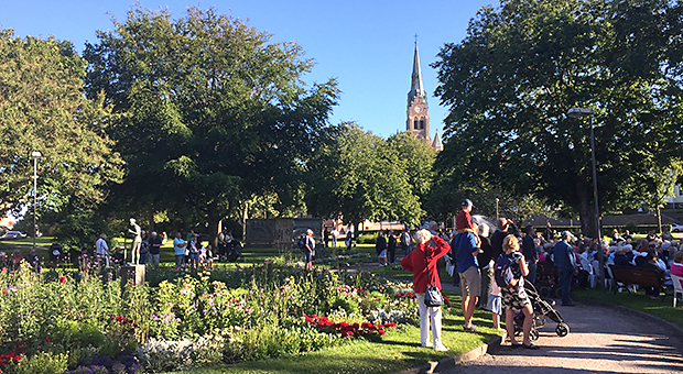 Foto av människor i stadsparken i Lysekil en solig sommardag.